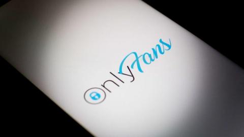 OnlyFans logo displayed on a smartphone screen in silhouette