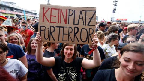 A festival goer holds up a sign that reads "no place for terror" at the Rock am Ring event in Germany (3 June 2017)