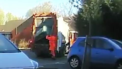 A still from the CCTV which shows a refuse collector dumping the bin into the back of a lorry