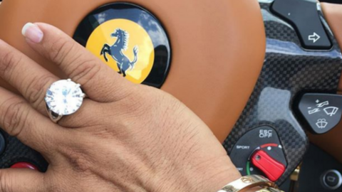 Anthony Gignac shares a photo of his hand, adorned in a large ring, resting against the wheel of his ferrari