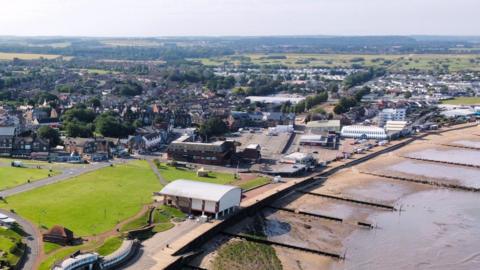 A drone image shows the coastline at Hunstanton, where you can also see a big car park, seafront buildings and a long beach