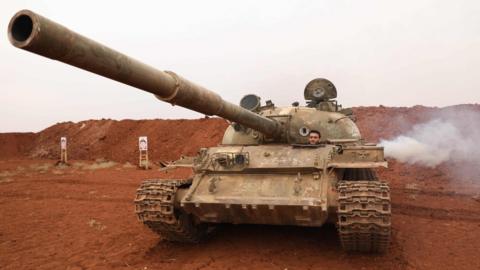 Syrian rebel fighter drives a tank that was withdrawn from a demilitarised zone along the front line in Idlib province (9 October 2018)