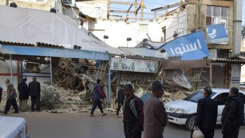 People look on around the damaged buildings after 6.4 magnitude earthquake that hit western Iran near the border with Iraq, in Tehran, Iran on 26 November 2018.