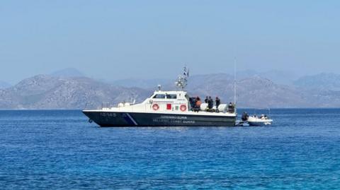 A Hellenic Coast Guard vessel in the sea near a coast