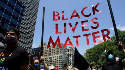 People hold a sign as they take part in a joint LGBTQ and Black Lives Matter march on the 51st anniversary of the Stonewall riots in New York City, New York, U.S. June 28, 2020.