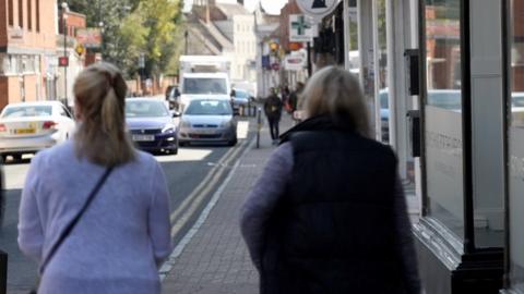 Backs of two women walking down street in Coleshill, north Warwickshire
