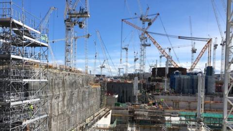 Wide shot of Hinkley Point C with the pump houses in the foreground and the reactor in the rear