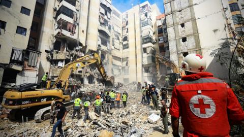 an excavator removes rubble caused by an airstrike in lebanon's capital city beirut