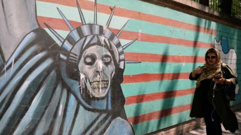 Woman walks past anti-US mural in Tehran (file photo)