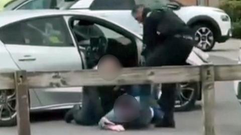 Still from a Facebook video showing an officer and a suspect