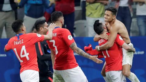Alexis Sanchez celebrates with the Chile team after scoring the decisive penalty against Colombia which sent them through to the semi-finals of the Copa America