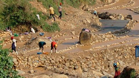 Workers, including women and children, work in a cobalt mine through small-scale and non-corporate mining activities referred to as "artisanal" mining, carried out under very poor conditions,