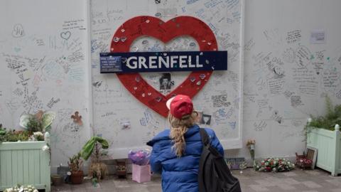 A mourner pays respects on the third anniversary of the Grenfell tower fire
