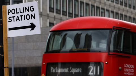 polling station sign and Parliament Square bus