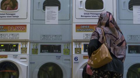 Woman standing in a laundrette