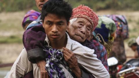 Displaced Kachin residents crossing Malikha river on a ferry to escape the fighting, on 26 April 2018