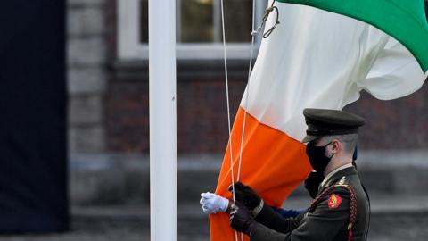 The Irish flag is raised during a ceremony marking the centenary of the handover of Dublin Castle