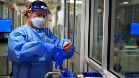 Nurse puts on PPE in Covid ward at King's College Hospital