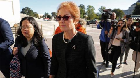 Former U.S. Ambassador to Ukraine Marie Yovanovitch (C) is surrounded by lawyers, aides and journalists as she arrives at the U.S. Capitol October 11, 2019