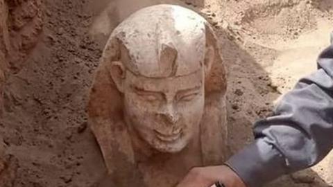 An archeological worker unearthing a Sphynx statue during in Egypt