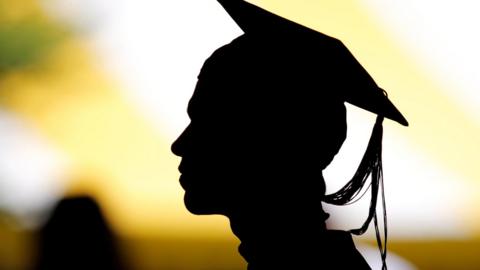 Silhouette of student taking their seat for the diploma ceremony at Harvard University