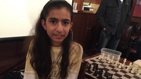 Jiya next to chessboard