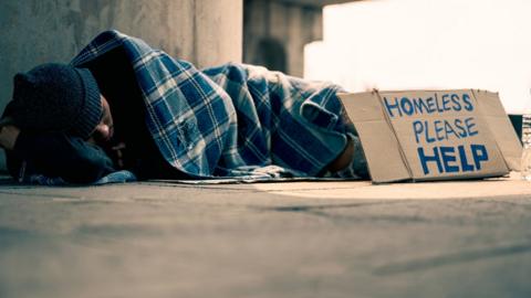 Stock image of homeless man lying on ground