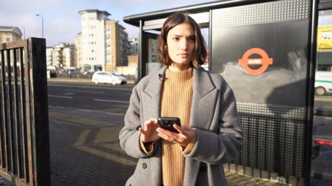 Woman using her phone in the street