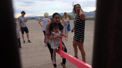 A-girl-and-mum-on-a-seesaw-at-the-US-MEXICO-BORDER.