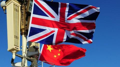 Union Jack flag is hoisted next to the flag of the Peoples Republic of China in front of Tiananmen Gate