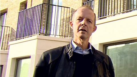 Nick Boles in front of homes