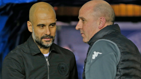 Manchester City boss Pep Guardiola greets Wigan boss Paul Cook before the two teams meet in the FA Cup in 2018