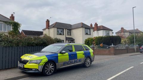 A police car parked outside a house on Church Road in Dundonald