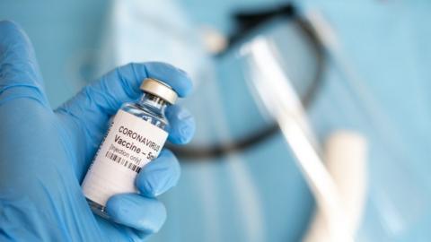 coronavirus vaccine held by blue gloved hand