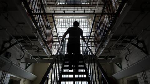 A man walking up stairs in a prison