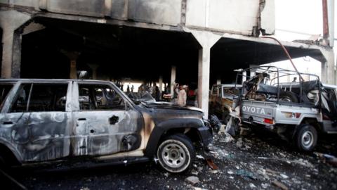 People stand at the site of an airstrike which witnesses said was by Saudi-led coalition aircraft on mourners at a hall where a wake for the father of Jalal al-Roweishan, the interior minister in the Houthi-dominated Yemeni government, was being held, in Sanaa, Yemen