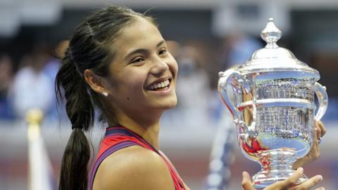 Great Britain's Emma Raducanu holds the trophy as she celebrates winning the women"s singles final