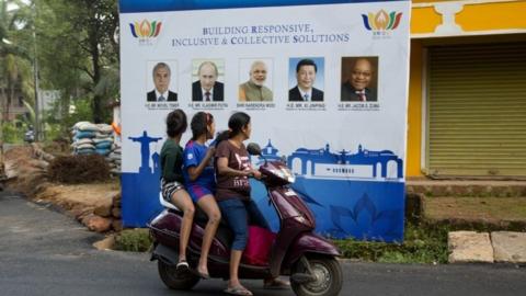 Locals in Goa stare at a poster for the Brics meeting