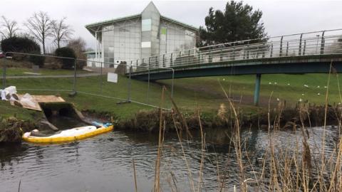 The culvert runs into the river in the town's park