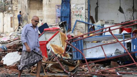 A man walks at the site of an explosion near the entrance of Aden international airport in Aden, Yemen October 31, 2021.