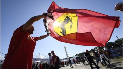 A Ferrari flag is flown by a fan at Imola