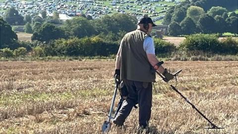 A man searching with a metal detector