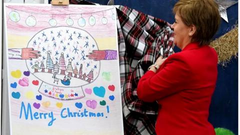 The first minister unveils the winning card design at a school in Glasgow