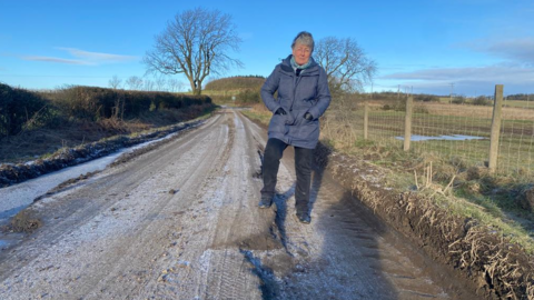 Councillor Heather Kidd by the damaged road