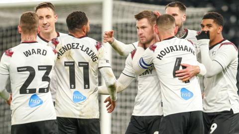 Derby County players come together to celebrate a goal