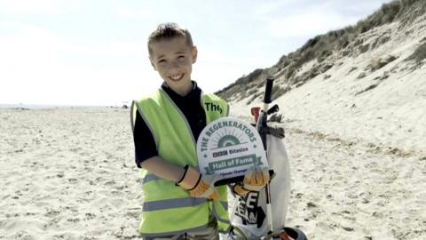 Theo with his BBC Regenerator award on Hemsby beach
