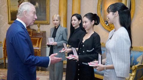 King Charles presents honorary MBE to members of Blackpink, with the king on the left and the four band members on the right