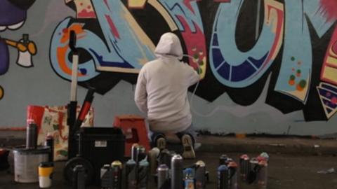 A graffiti artist painting a wall