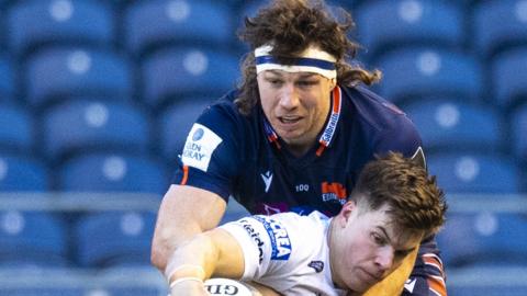 Edinburgh's Hamish Watson tackles Huw Jones of Glasgow