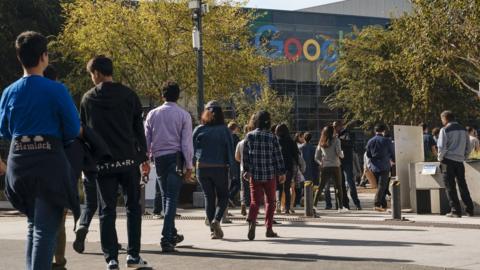 Google employees stage a walkout in November 2018 over sexual misconduct allegations, with the headquarters visible in the background